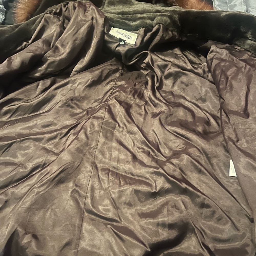 It’s a brown fur coat with a hood in good condition.